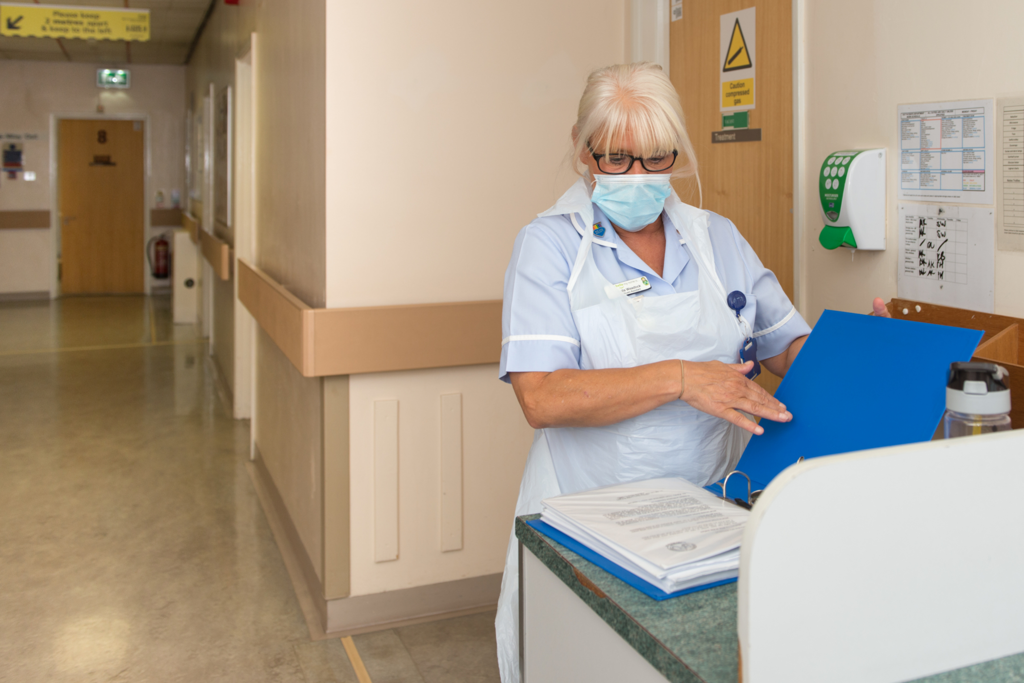 Image of nurse opening a file 